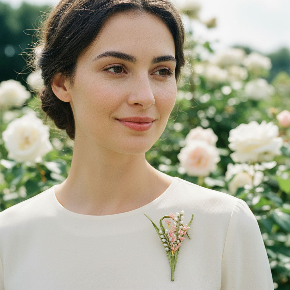 Model wearing a handcrafted floral brooch in lily of the valley design in garden
