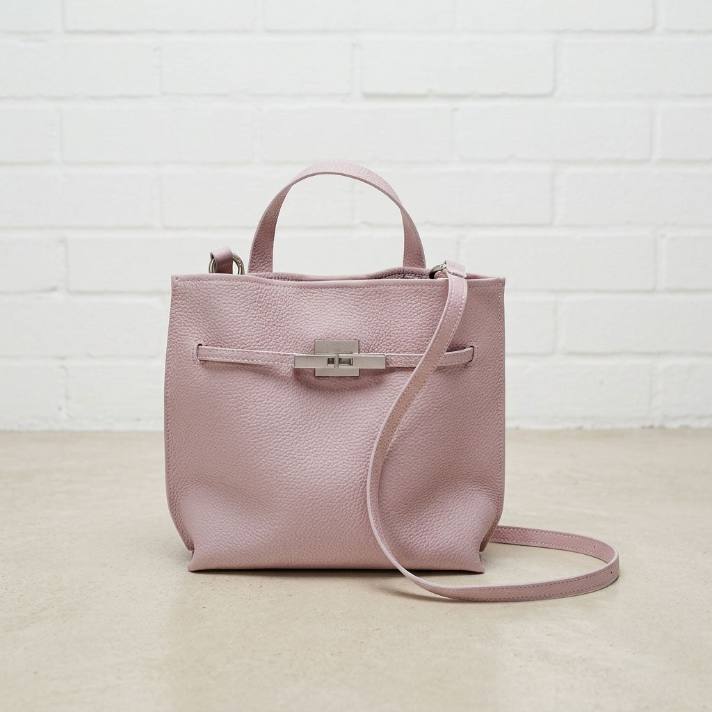 Blush Pink Soft Grain Mini Shoulder Bag featuring a compact silhouette, front pocket, top handle, and adjustable shoulder strap.