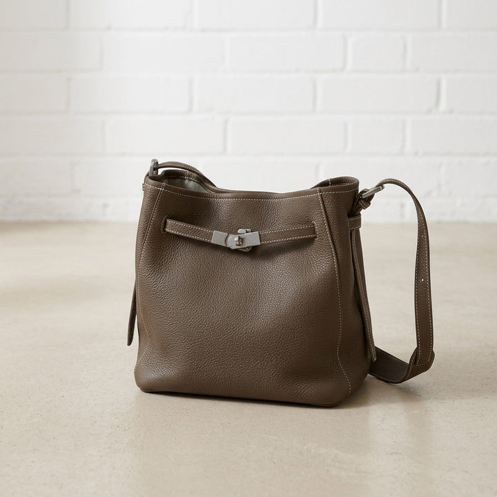 Dark Taupe Belted Bucket Bag featuring a relaxed silhouette, pebbled leather texture, and polished silver-tone belted detail.