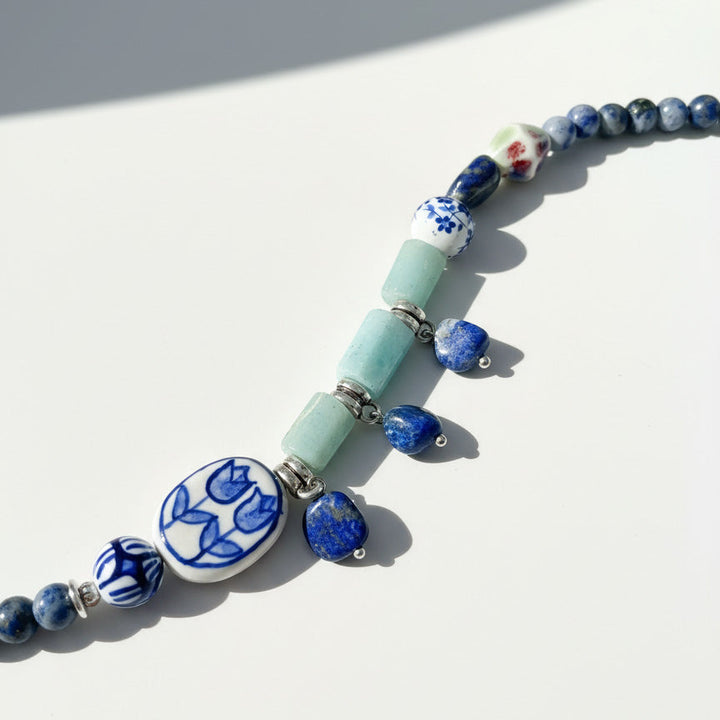 Necklace with blue and white floral beads on a white background