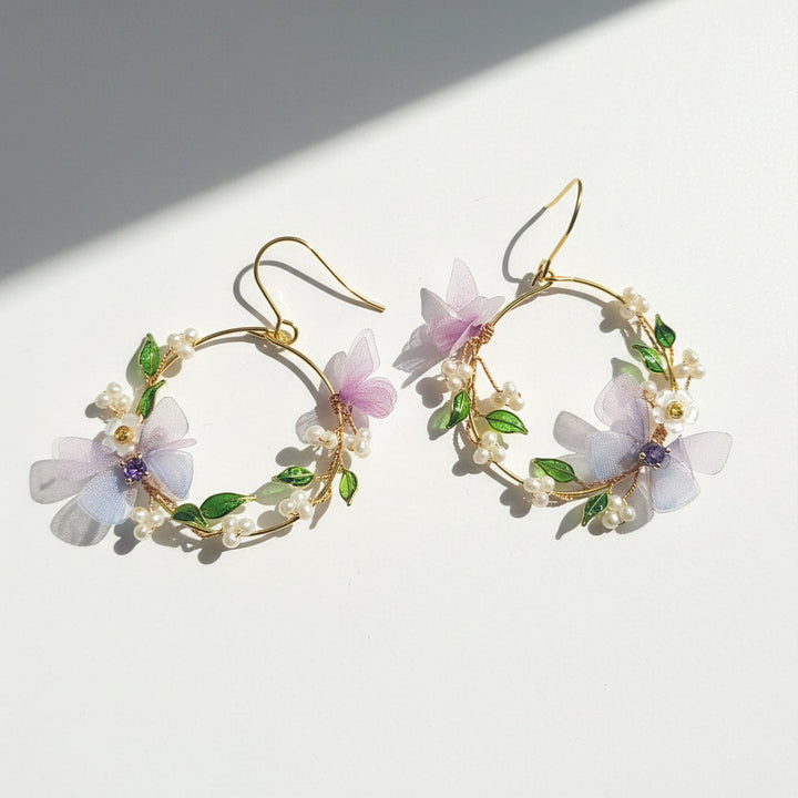 Floral hoop earrings with gold accents on a white background