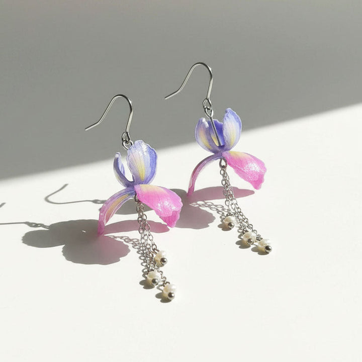 Pair of colorful earrings with floral designs on a light background