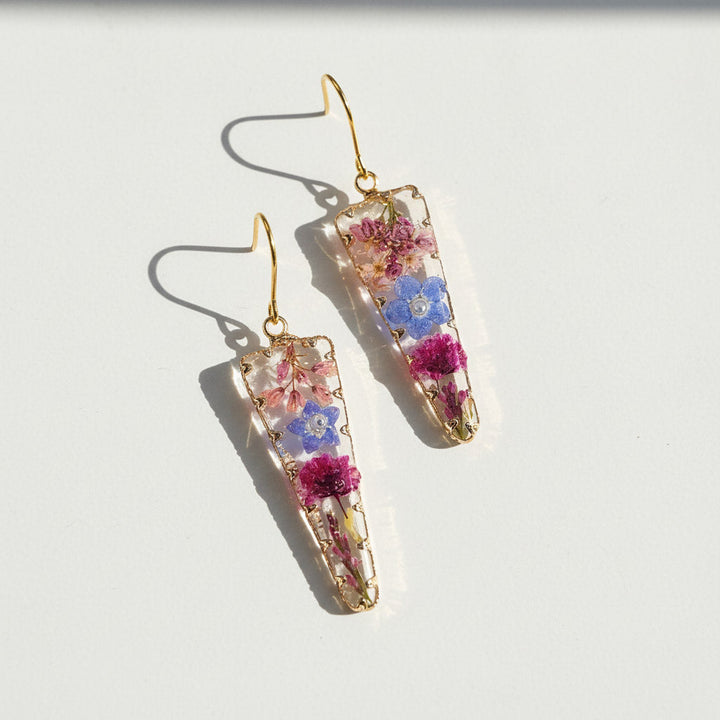 Pair of floral earrings with gold hooks on a white background