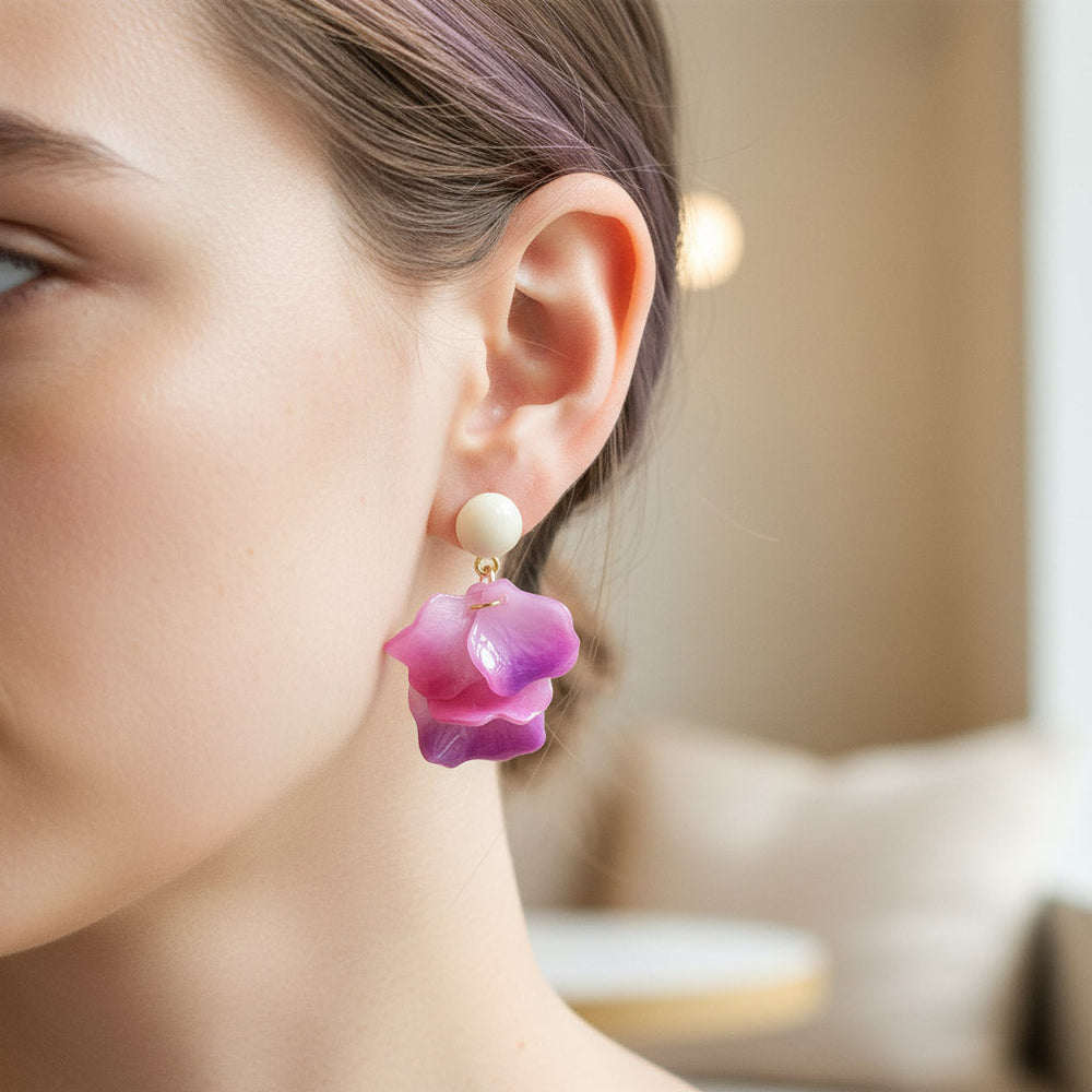 Close-up of a woman wearing a pink floral earring with a blurred background