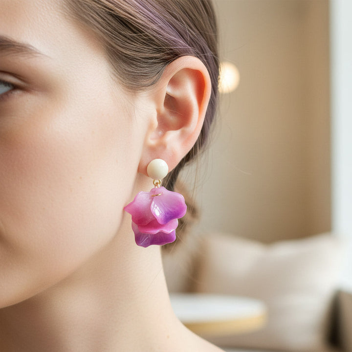 Close-up of a woman wearing a pink floral earring with a blurred background
