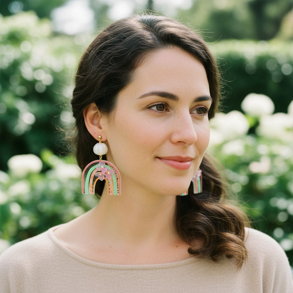 Woman wearing colorful earrings with a blurred green background