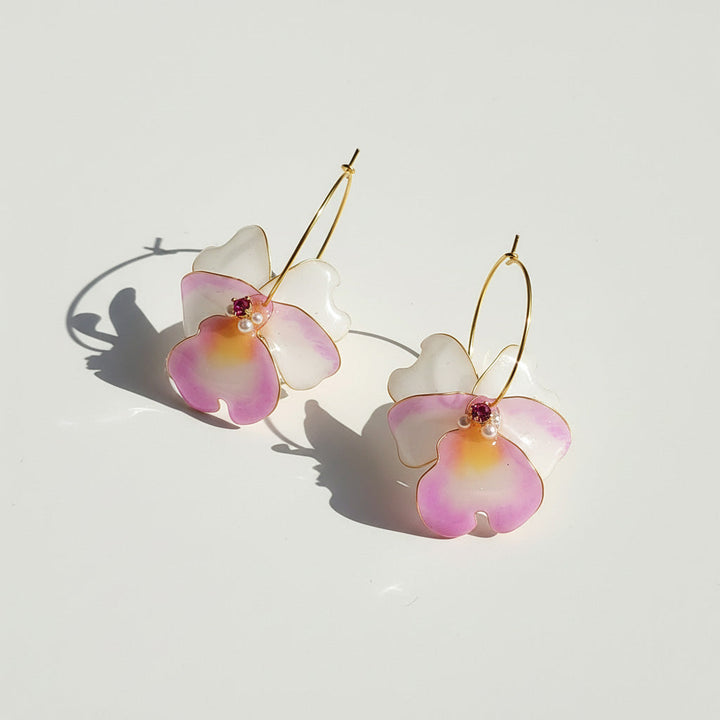Gold hook earrings with hand-painted pink and white orchid flowers, accented with pearls and crystals.