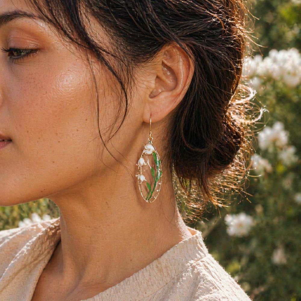 Close-up of a woman wearing a floral earring with a blurred natural background