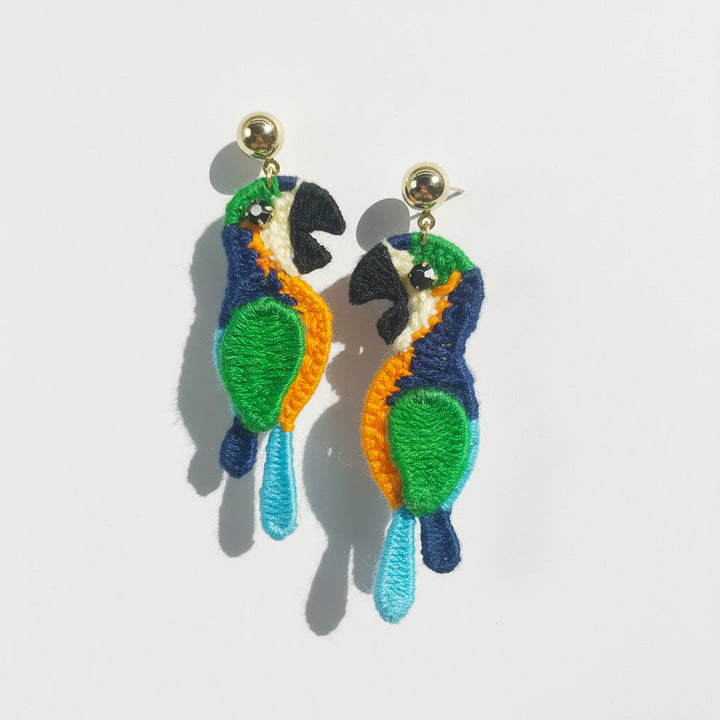Pair of parrot-shaped earrings on a light gray background