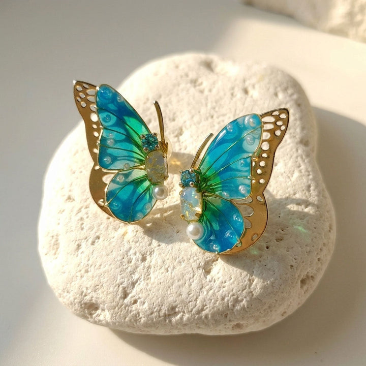 March birthstone butterfly earrings on a white stone