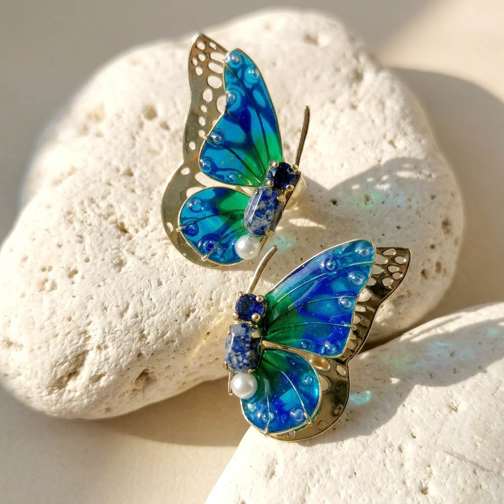 September birthstone butterfly-shaped earrings on a white stone surface