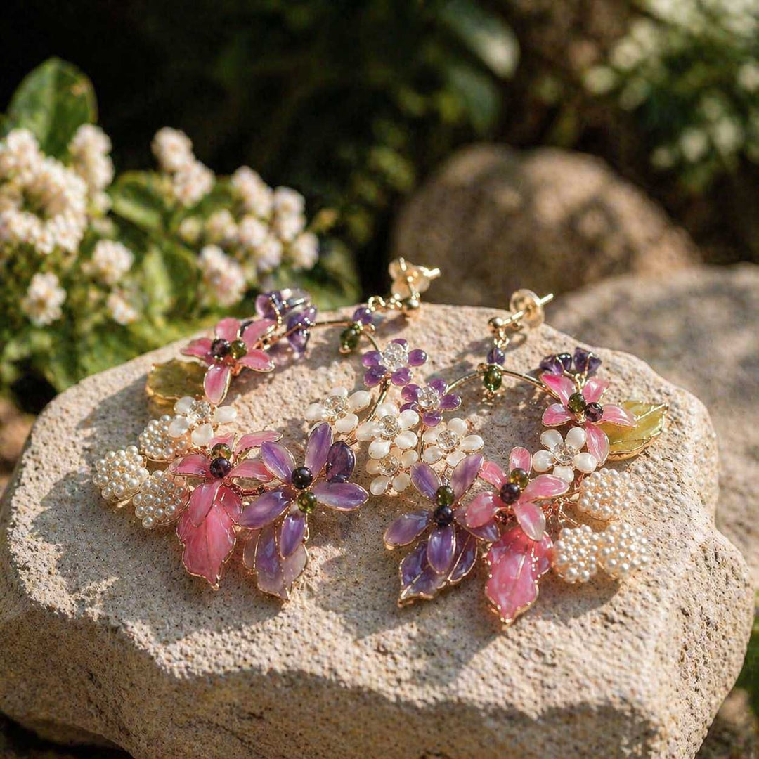 Bracelet with pink and purple floral beads on a stone surface with flowers in the background
