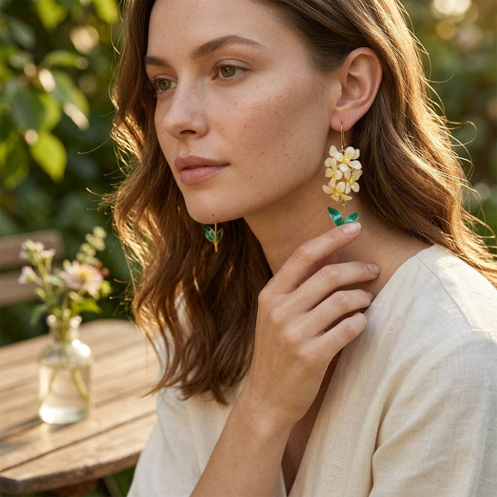 Woman wearing floral earrings outdoors with a blurred natural background