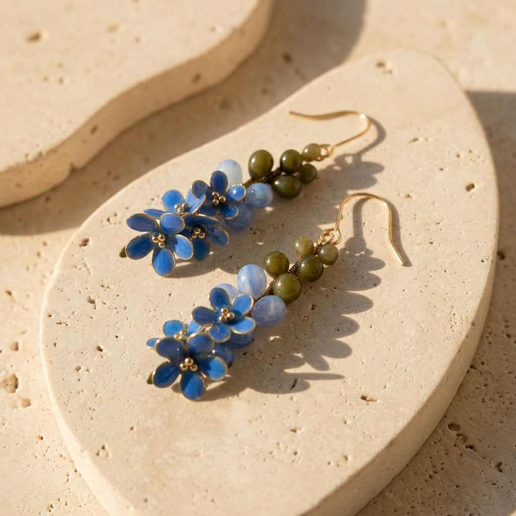 Forget-me-not floral earrings on a beige stone surface