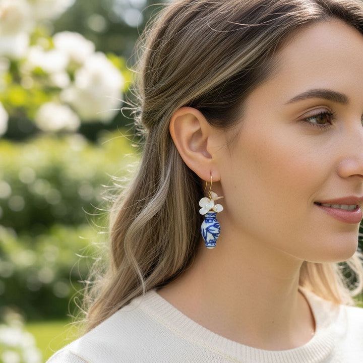Woman wearing floral earrings with a blurred natural background
