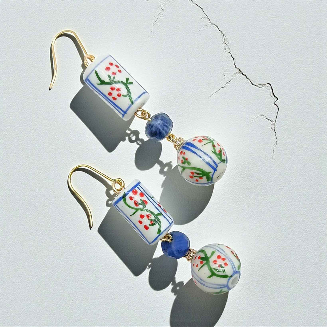 Pair of earrings with floral designs on a light gray background