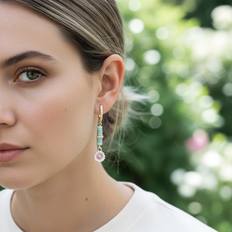 Model wearing A2K London amazonite and floral enamel earrings in garden sunlight, elegant style.