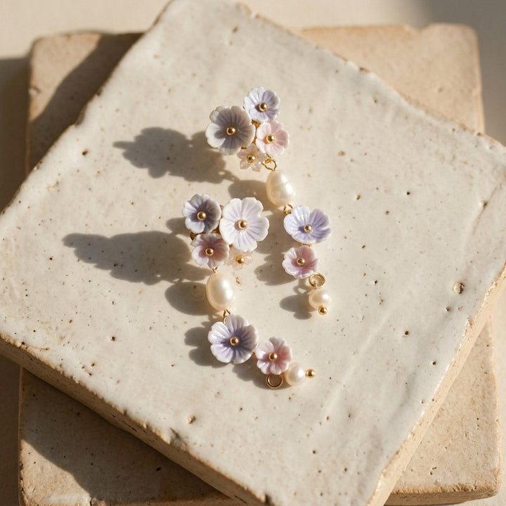 Floral earrings with pearls on a textured stone surface