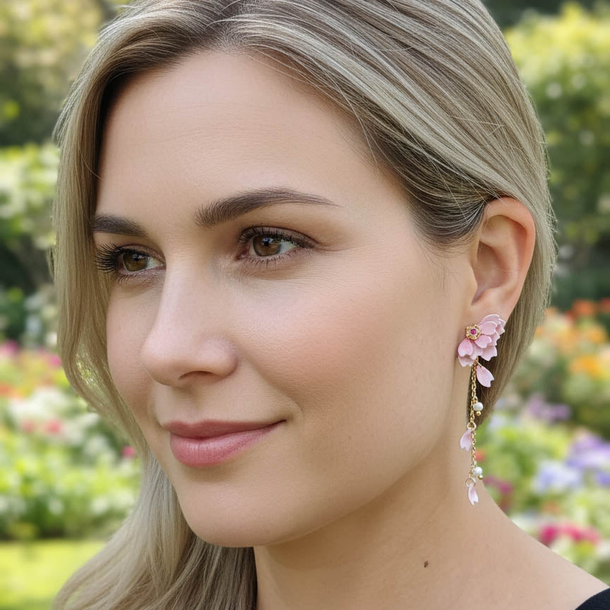 Woman wearing floral earrings with a blurred garden background