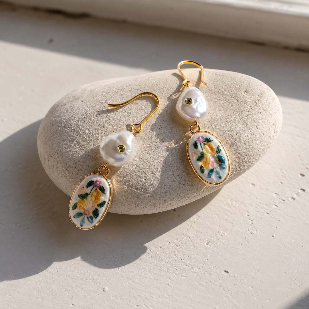 Porcelain floral pearl earrings with baroque pearls and 18K gold-plated stainless steel hooks on a stone surface