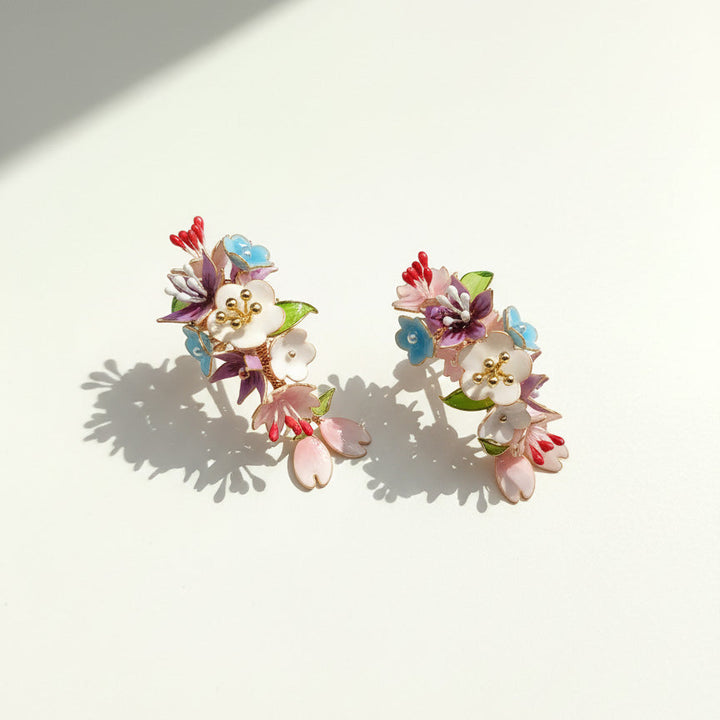 Colorful floral earrings on a light background