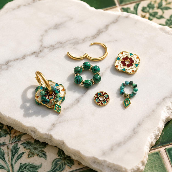 Convertible hoop earrings with malachite, African turquoise and hand-painted enamel shown with interchangeable components on a white marble slab with a green patterned tile surface underneath.