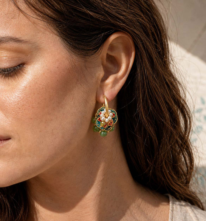 Woman wearing Moss Garden convertible hoop earrings with freshwater pearls and green gemstones