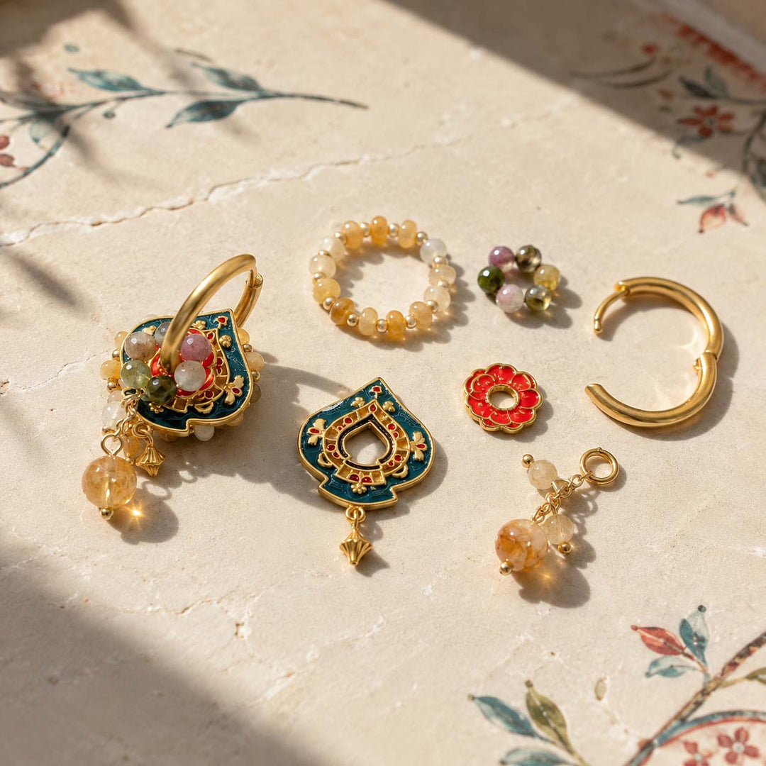 Convertible hoop earring components with Citrine, Yellow Jade, Tourmaline and hand-painted enamel on a textured cream surface with floral print and soft shadows. 
