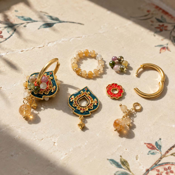 Convertible hoop earring components with Citrine, Yellow Jade, Tourmaline and hand-painted enamel on a textured cream surface with floral print and soft shadows. 