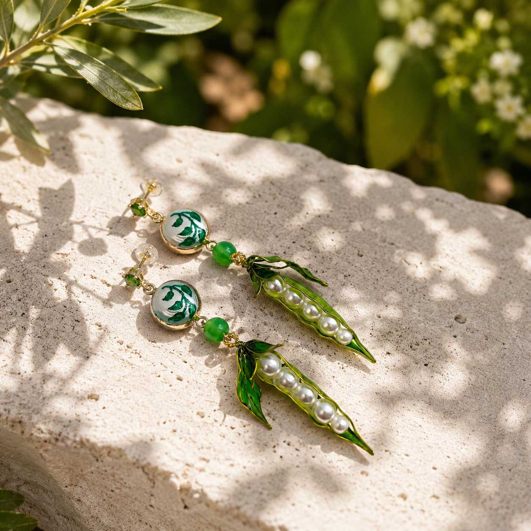 Woman wearing Pea Pod &amp; Baroque Pearl Drop Earrings with hand-painted enamel pea pods, glass pearls, hand-painted baroque pearls, jade beads and sparkling CZ studs.