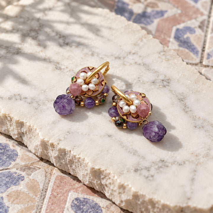 Amethyst rose convertible hoop earrings with freshwater pearls and strawberry quartz on a marble slab.