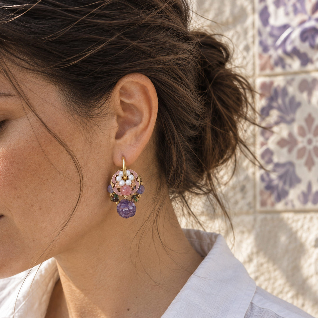 Model wearing amethyst rose convertible hoop earrings outdoors against a pale stone wall.