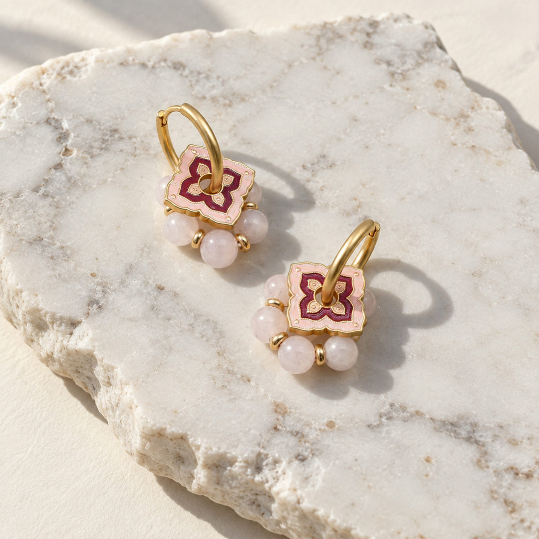 Pink quartz convertible hoop earrings with layered pink enamel details on a sunlit marble slab.