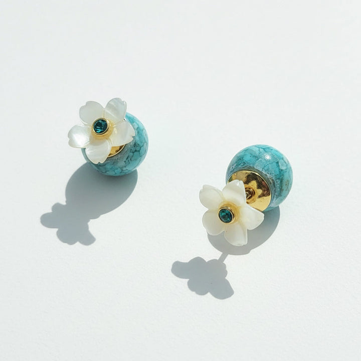 Pair of earrings with floral design on a light gray background