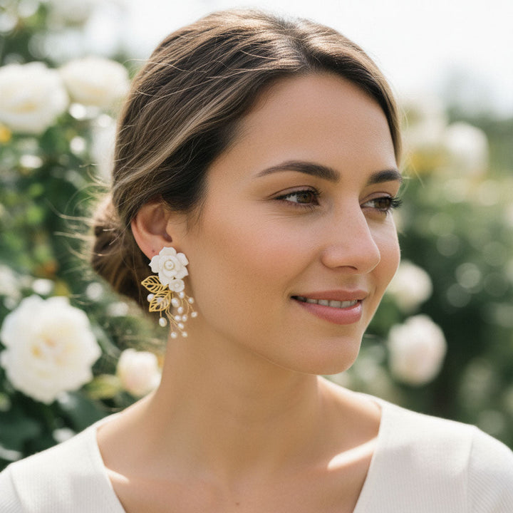 Woman wearing floral earrings with a blurred floral background