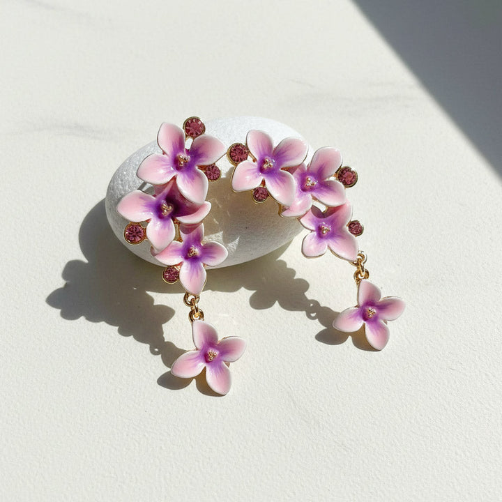 Floral earrings with pink and purple flowers on a light background