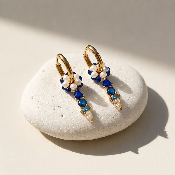 September Sapphire convertible huggie earrings featuring freshwater pearls, blue semi-precious stones and sparkling CZ glass accents.