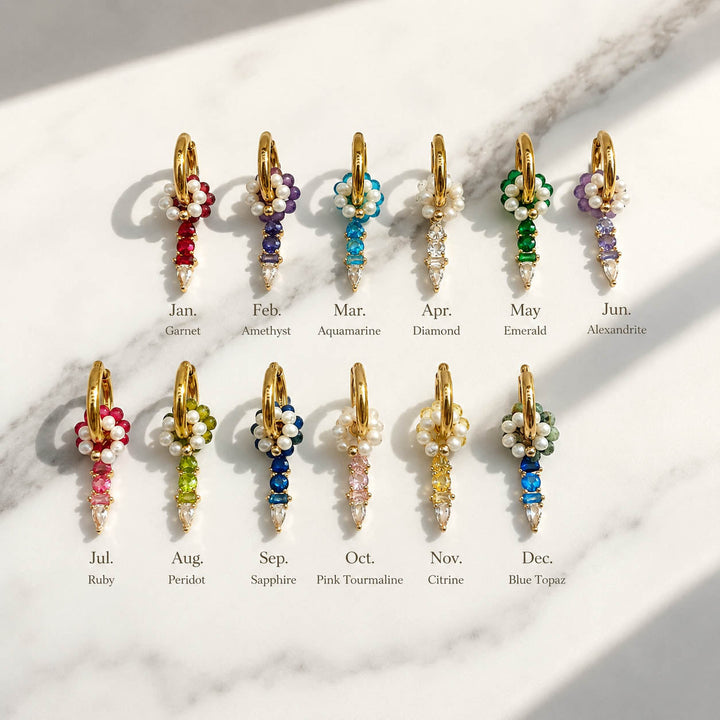 Convertible birthstone huggie earring shown with removable freshwater pearl floral ring, semi-precious stone ring, birthstone charm and 18K gold-plated stainless steel hoop.