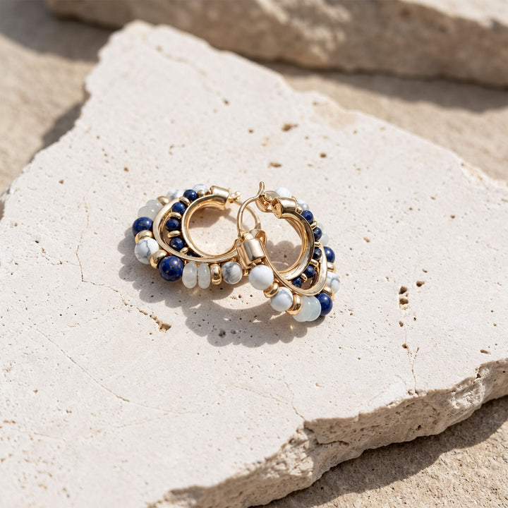 Layered Lapis Lazuli, Amazonite and White Turquoise hoop earrings displayed on limestone in sunlight
