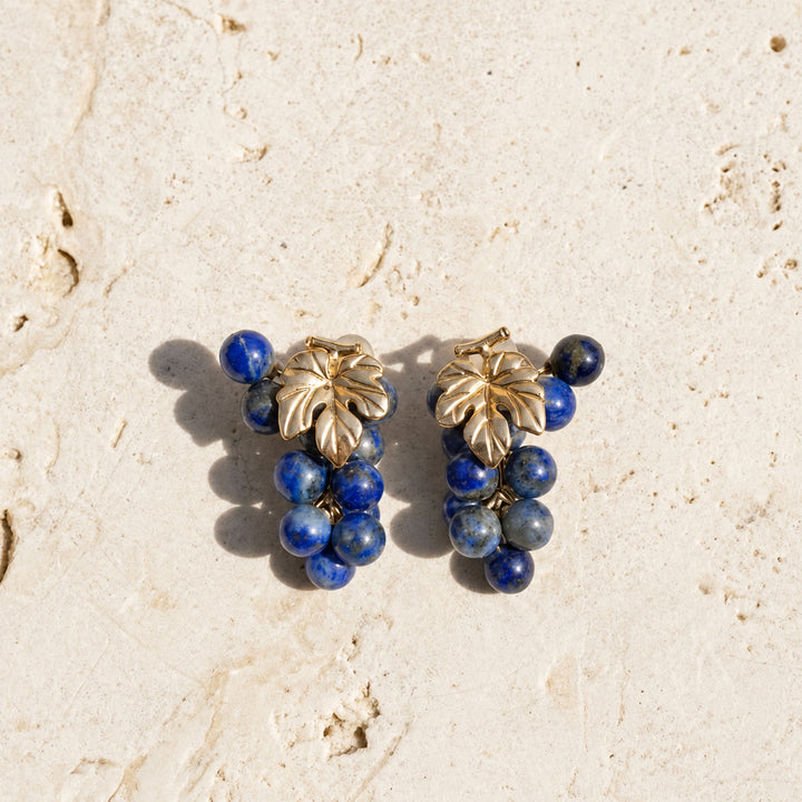 Lapis Lazuli Grape Cluster Earrings with natural blue gemstone beads and sculpted gold leaf details on limestone