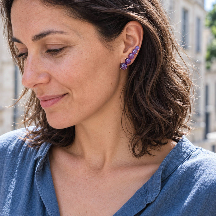 Model wearing Amethyst Ear Climber Earrings with graduated violet gemstones and gold-plated setting