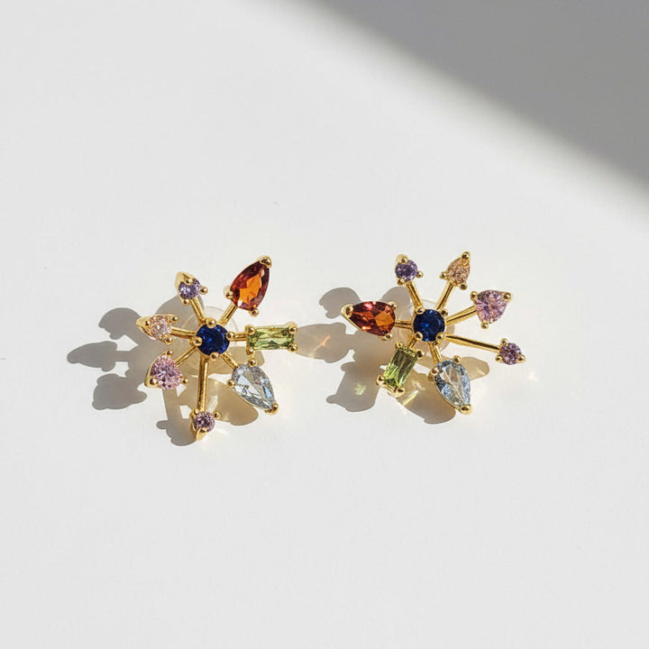 Multicolor starburst CZ stud earrings in gold plated brass on white background, sparkling crystal design by A2K London.