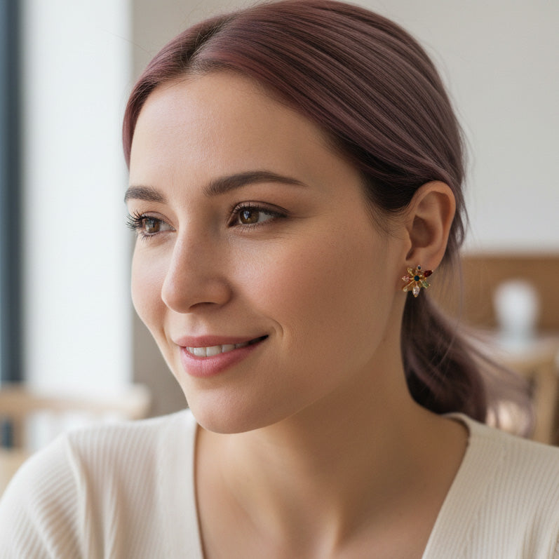 A2K London gold starburst stud earrings with multicolor CZ stones, small geometric sparkle design.