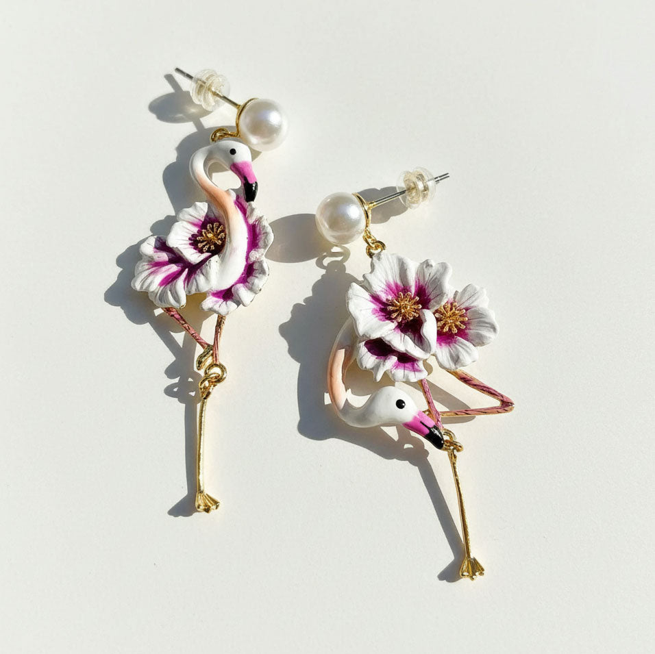 Flamingo-shaped earrings with floral details on a light background