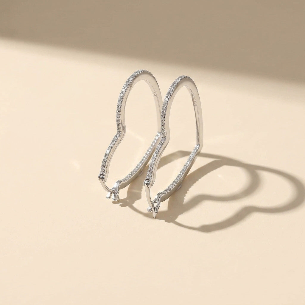 Silver hoop earrings with moissanite diamonds on a beige background