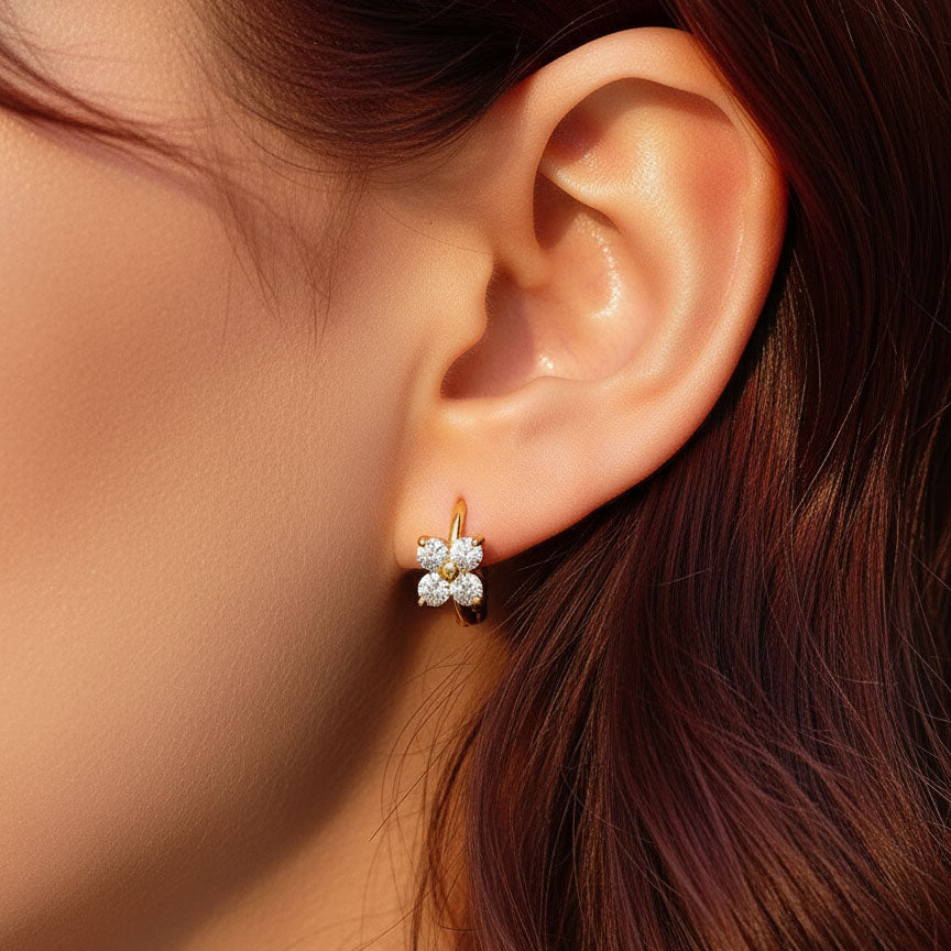 Model wearing gold floral huggie earrings with brilliant moissanite sparkle