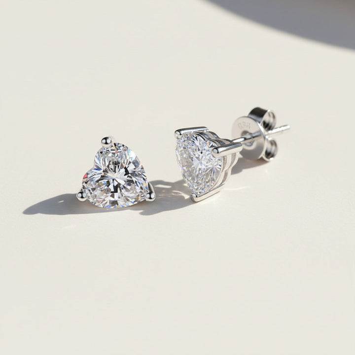 Close-up of platinum-plated heart-cut moissanite studs with butterfly backs