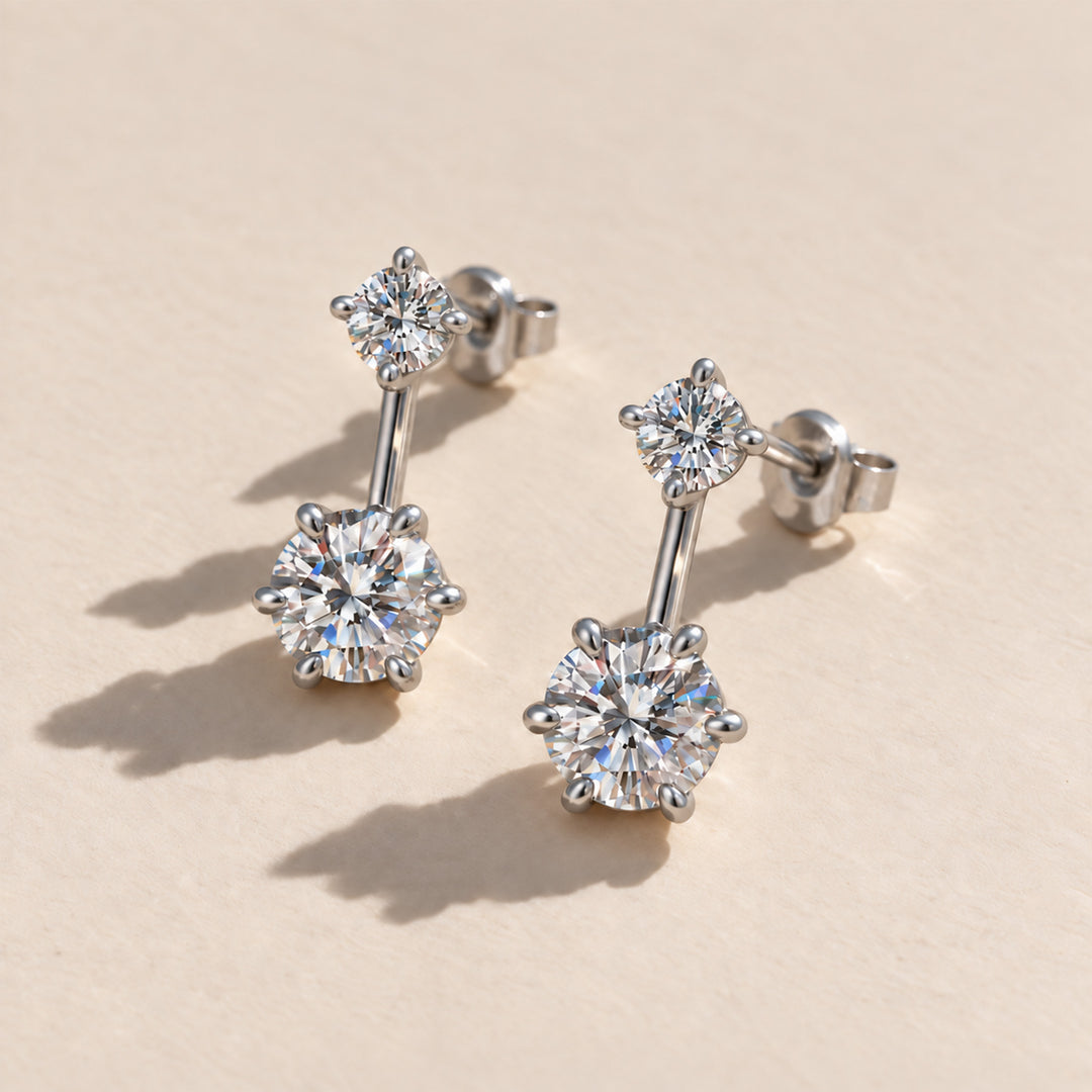 Two-stone moissanite ear jacket earrings worn on the earlobe in natural sunlight