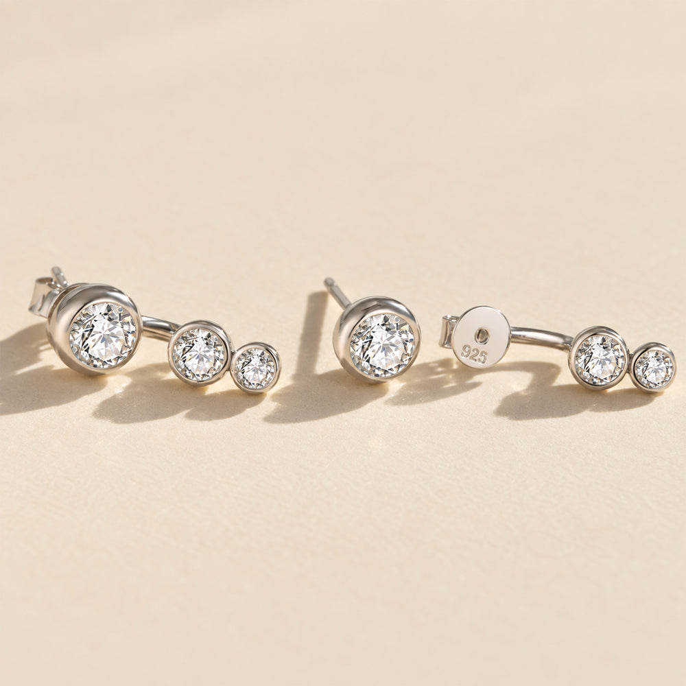 Silver three-stone moissanite ear jacket earrings showing the curved jacket design