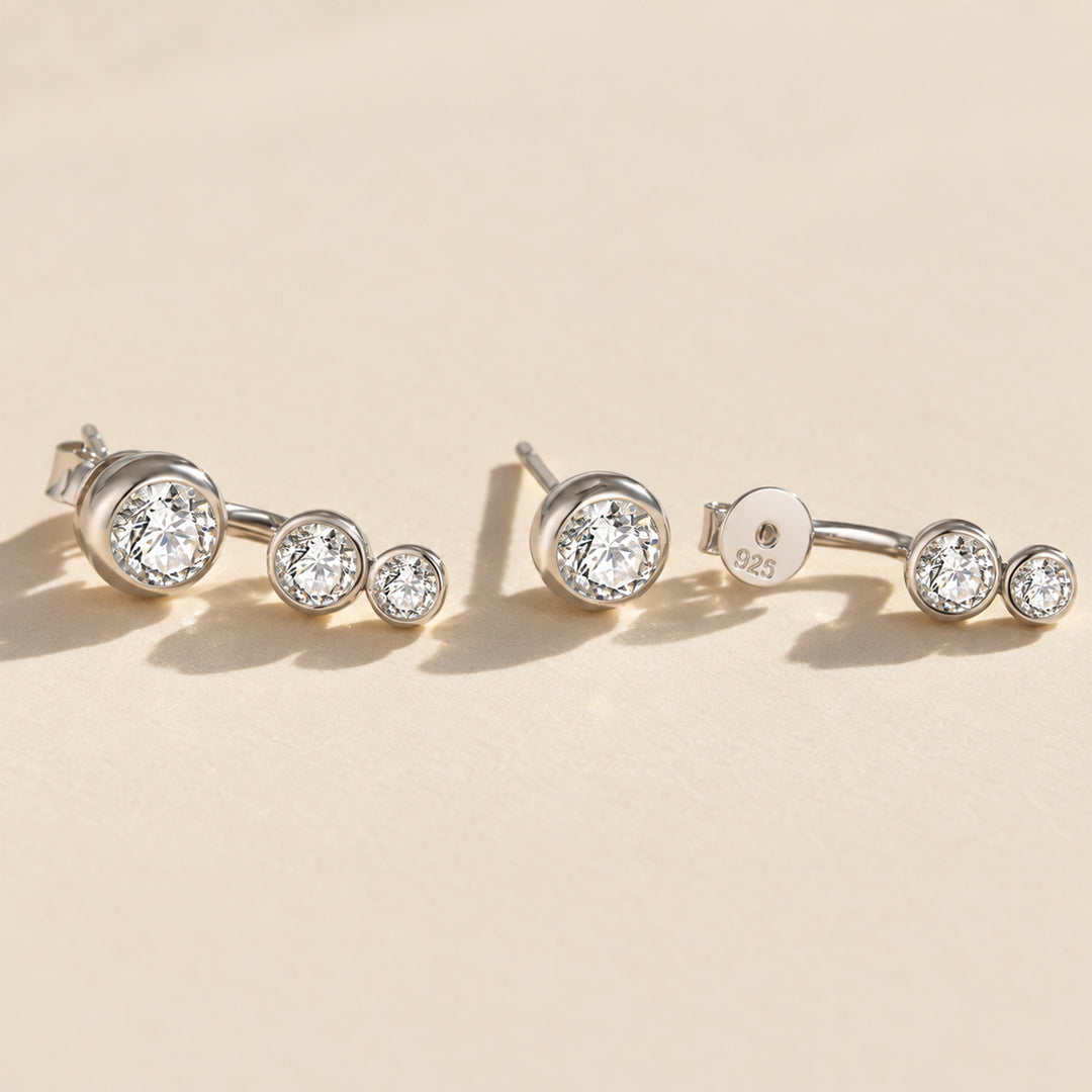 Silver three-stone moissanite ear jacket earrings showing the curved jacket design